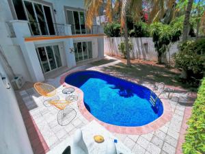 - une piscine en face d'une maison dans l'établissement BEAUTIFUL & COZY NEAR BEACH Apartment Pool & KingSize Bed, à Cancún