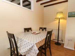 uma sala de jantar com uma mesa com cadeiras e um candeeiro em Jenny's Cottage em Northallerton