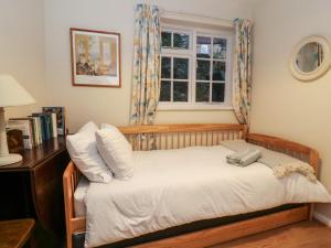 a small bedroom with a bed with a window at Jenny's Cottage in Northallerton