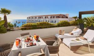 eine Terrasse mit Tischen und Stühlen und Meerblick in der Unterkunft Hôtel Barrière Le Gray d'Albion in Cannes