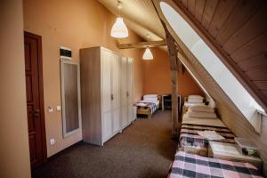 um quarto no sótão com 3 camas e um arco em Guest House "Arkhistratyg" em Lviv