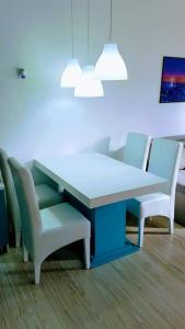 une table et des chaises dans une pièce dotée d'un mur bleu dans l'établissement Apartman Ivanović 6, à Sokobanja