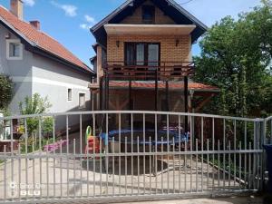 une clôture blanche devant une maison dans l'établissement Apartman Ivanović 6, à Sokobanja