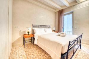 a bedroom with a large bed and a window at ApartmentsArena - Suite Mercatorum - Piazza Erbe in Verona