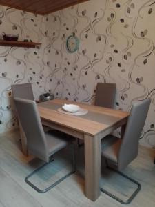 a wooden table with two chairs and a wall at Haus Heidrun in Dolgesheim