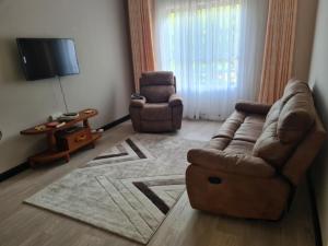 sala de estar con sofá y 2 sillas en Lovely 3-Bed Apt @Palm Ridge next to Vipingo Ridge en Vipingo