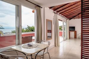 a dining room with a table and a view of the ocean at Mata Hari Apartamentos in Búzios