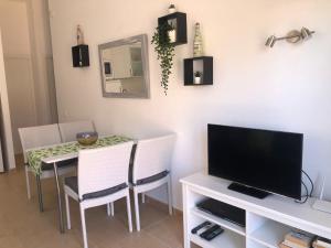 a dining room with a table and a television at Garbí & Xaloc apartamentos in Cala Galdana