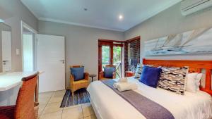 a bedroom with a large bed and a bathroom at San Lameer Supreme by Top Destination Rentals in Southbroom