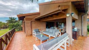 a patio with couches and chairs on a balcony at San Lameer Supreme by Top Destination Rentals in Southbroom
