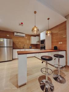 a kitchen with a counter and two bar stools at Khobar Luxury Apartment in Al Khobar