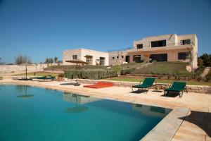 uma casa com piscina em frente a uma casa em Tassourt Lodge em Essaouira