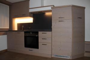 a kitchen with wooden drawers and a counter top at Pedrin's House in Livigno