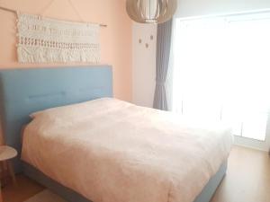 1 dormitorio con cama blanca y ventana en Penthouse Puro en Cabanas de Tavira