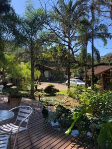 een houten terras met stoelen en een vijver bij Pousada Arraial do Ouro in Gaspar +86 foto's