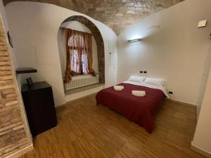sypialnia z czerwonym łóżkiem i oknem w obiekcie Heart of San Lorenzo - La casa particular w Rzymie