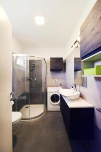 a bathroom with a shower sink and a washing machine at Residence Le Querce in Cordovado
