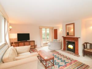 a living room with a couch and a fireplace at The Reading Room in Lopen