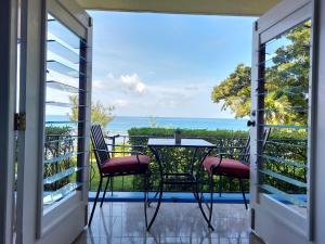 a balcony with a table and chairs and the ocean at Contemporary Ocean view 2bed Carib Ocho Rios Condo in Ocho Rios