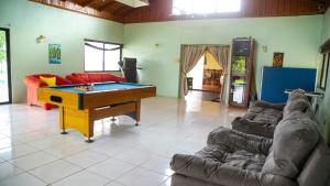 a living room with a ping pong table and couches at Marantha Villa in Discovery Bay