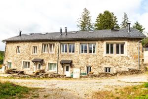 una antigua casa de piedra con techo negro en GITE AUTOMNE, en Le Soulié