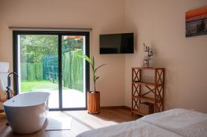 a bedroom with a tub and a sliding glass door at Las Mareas de Llanes in Andrín