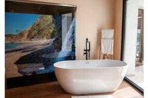 uma banheira branca na casa de banho com um quadro em Las Mareas de Llanes em Andrín