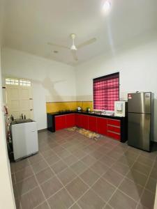 a kitchen with red cabinets and a stainless steel refrigerator at AYAHLONG BEACH GUESTHOUSE in Kampong Sura Masjid