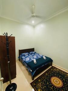 a bedroom with a bed and a rug in a room at AYAHLONG BEACH GUESTHOUSE in Kampong Sura Masjid