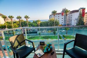 een balkon met een tafel en stoelen en uitzicht op een gebouw bij Kleopatra blue hawai hotel in Alanya