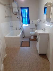 a bathroom with a tub and a sink and a toilet at Weltevreden Guest Farm in Klavervlei +21 photos