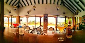 a dining room with a table and chairs and windows at GENKI LUXURY GLAMPING in Villa de Leyva