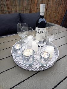 un plato con una botella de vino y copas en una mesa en Gemini Vendégház, en Harkány