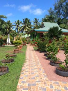 a brick path in front of a house with plants at Benjamine's Guesthouse in La Digue