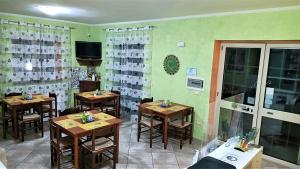 a dining room with wooden tables and a tv at Il Laghetto in Castrovillari