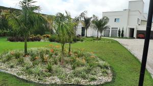 a garden with palm trees and flowers in front of a building at Mix aparts Tijucas -kit 10 in Tijucas +15 photos