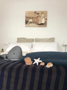 a bed with a blue blanket and some shells on it at Lanzarote Famara Beach in Famara