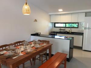 嘎林海斯港的住宿－Privê Portal do Sol，一间带木桌和椅子的厨房以及一间用餐室