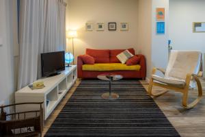 een woonkamer met een bank en een tv bij Vale71house in Porto