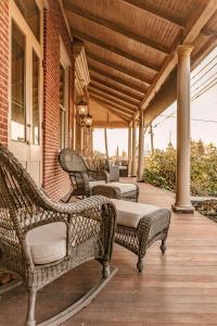 eine Veranda mit drei Korbstühlen auf einem Haus in der Unterkunft The Londonderry Inn in Hershey