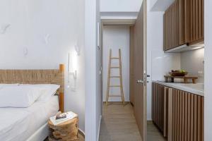 a bedroom with a bed and a kitchen with a ladder at Boho Sapiens Marina - Romantic Cave in Adamas