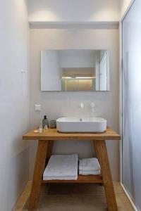a bathroom with a sink and a mirror at Boho Sapiens Marina - Romantic Cave in Adamas