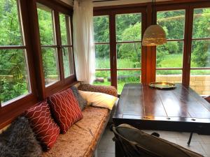 sala de estar con sofá, mesa y ventanas en Bungalows am Waldessaum bei Hohenzieritz, en Hohenzieritz