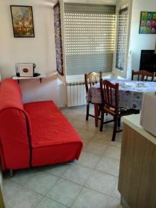 sala de estar con sofá rojo y mesa en Appartamento Marina, en Finale Ligure