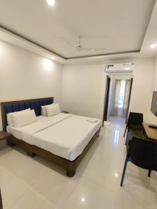a bedroom with a bed and a desk in it at Airport Regency in Devanhalli