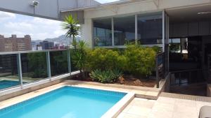 a swimming pool on the roof of a building at Apart-Hotel de Luxo em Lourdes in Belo Horizonte