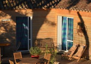 a patio with chairs and a table and a window at Les Chênes Bleus in Sainte-Marie-de-Ré