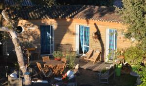 a house with a patio with a table and chairs at Les Chênes Bleus in Sainte-Marie-de-Ré