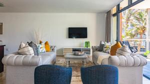 a living room with two couches and a tv at COZY LUXURY 3 BRM 4 BED in Durban