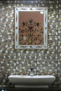 a bathroom with a sink and a mirror on a wall at Golden Peacock Heritage Home Stay in Jaipur